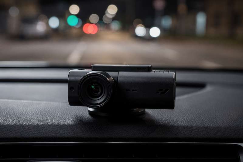 High-quality dash cam mounted on vehicle windshield recording dark road at night with clear footage.