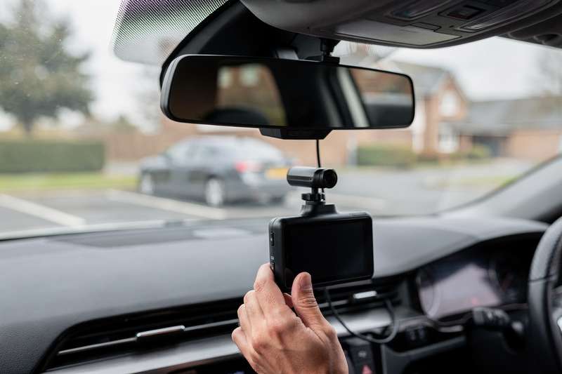 Dual-channel dash cam system mounted on vehicle windshield capturing front and rear road footage simultaneously.