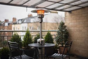 Compact 2kW electric patio heater mounted on a small covered UK balcony, providing efficient warmth for intimate outdoor spaces.