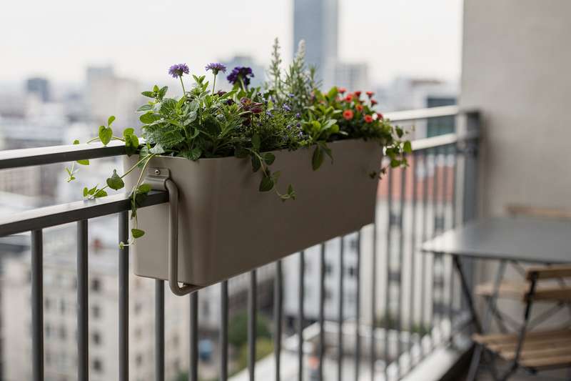 Sleek railing planter box mounted on narrow balcony edge without drilling or permanent installation.