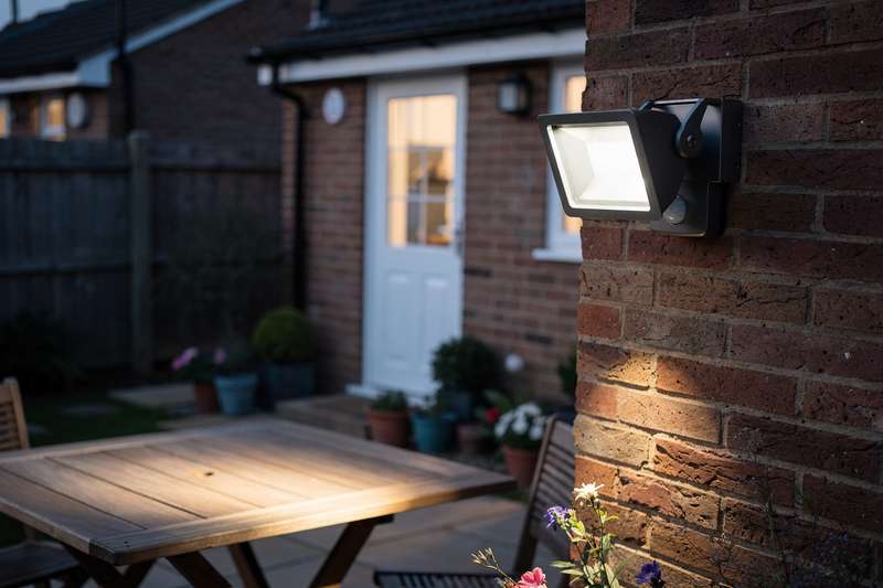 Motion-activated security floodlight mounted on exterior wall of UK home for enhanced nighttime protection.