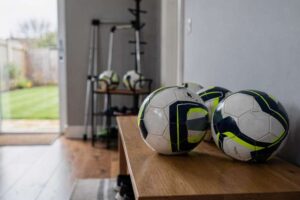 Selection of regulation footballs displayed on grass field ready for play.
