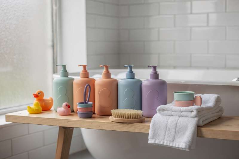 Colorful bath toys and gentle cleansing products arranged on a white bathroom shelf for kids.