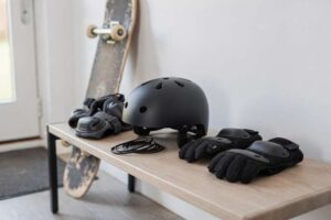 Skateboarder wearing protective helmet, wrist guards, and knee pads during outdoor practice session.