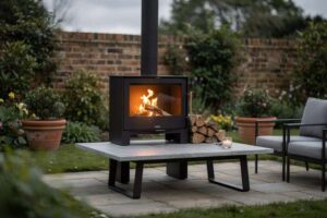 Modern outdoor fireplace with stone surround on a residential UK patio surrounded by garden seating.