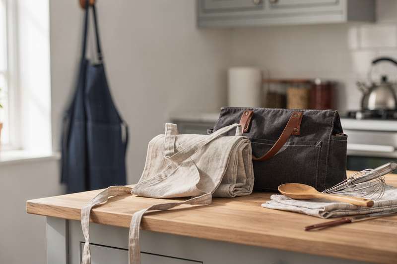 Professional and casual cooking aprons displayed for kitchen and outdoor grilling activities.
