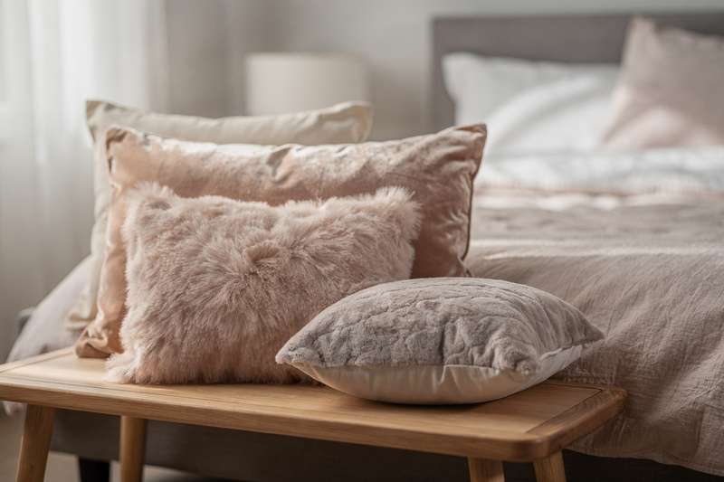 Premium plush pillows arranged on a bed showing soft textures and varied shapes for sleeping and relaxation.