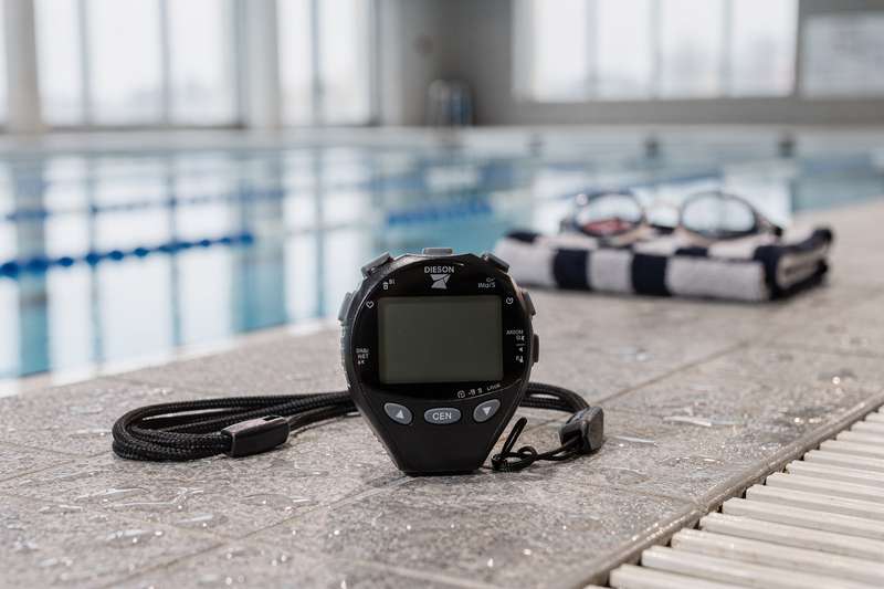 Digital and analog stopwatches displayed for sports timing and competitive swimming training.