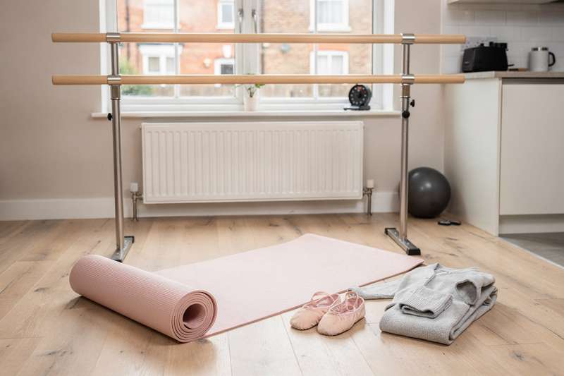 Essential ballet equipment including barres, mats and mirrors arranged in a home studio setup.
