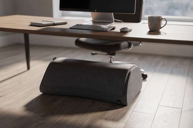 Heated footrest positioned under an office desk providing warmth during cold winter workdays.