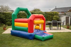 Colorful inflatable bouncy castles set up on a spacious UK garden lawn for children's outdoor entertainment.