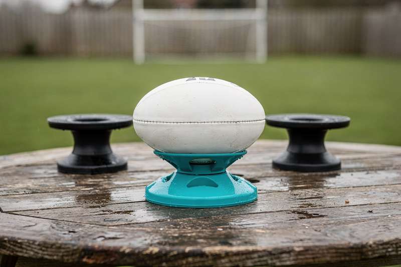 Various rugby kicking tees displayed on grass showing different designs and heights.