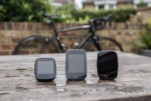 Cyclist checking digital display on handlebars showing distance and speed metrics during outdoor ride.