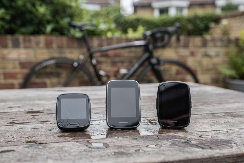 Cyclist checking digital display on handlebars showing distance and speed metrics during outdoor ride.
